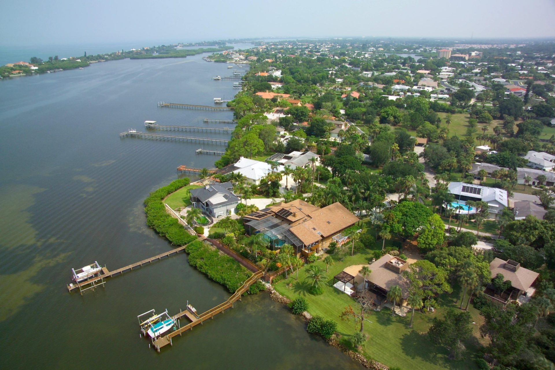 Scenic Overhead View of Osprey, FL - Serene Waterfront Community with Residential Houses, Boat Docks, and Natural Beauty