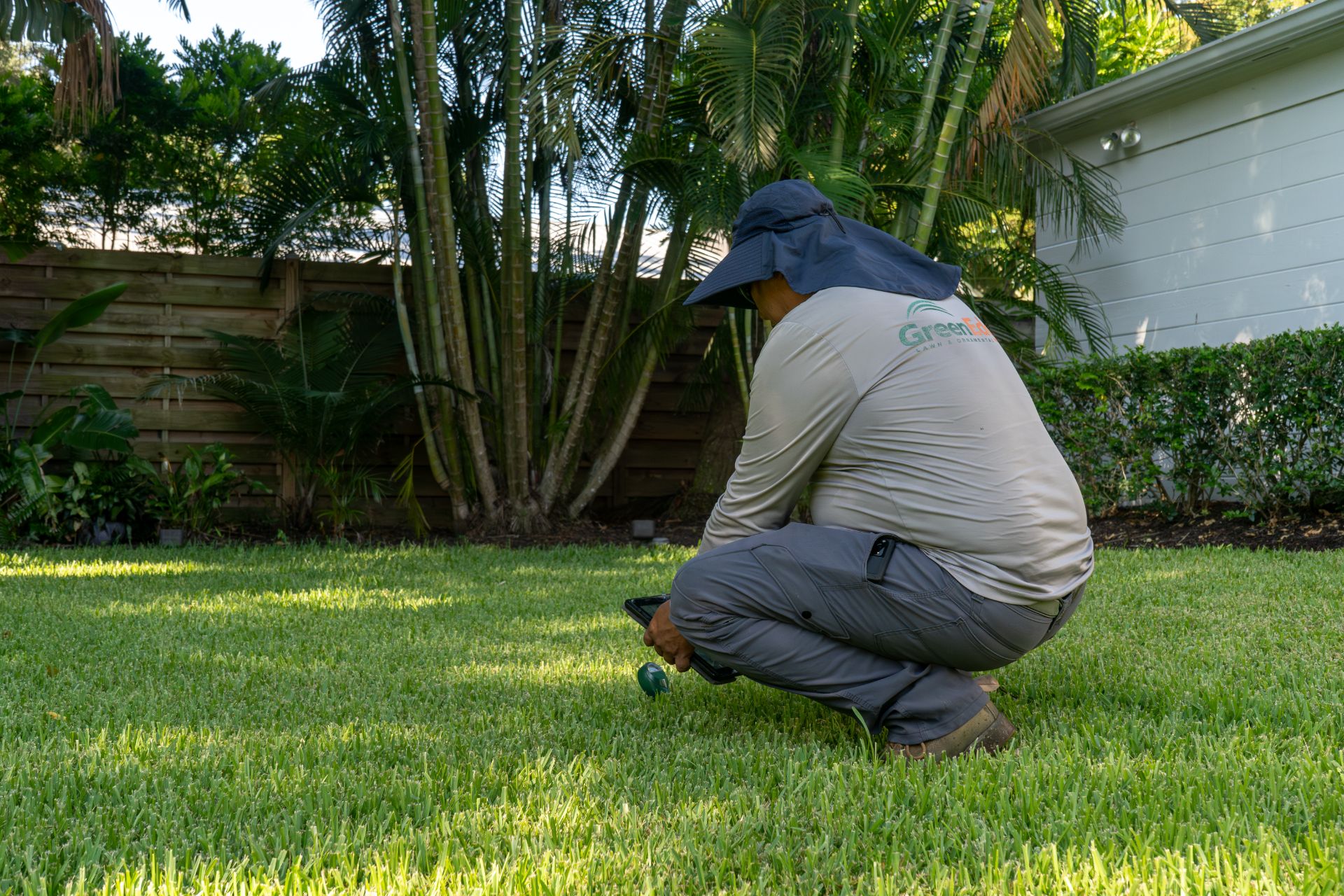 A GreenEdge staff member diligently assessing the health of the grass and taking notes in Sarasota. Our team carefully examines the condition of the grass, noting any issues or concerns for appropriate treatment and care. Trust GreenEdge for expert grass health evaluations and personalized strategies to promote a lush and vibrant lawn.