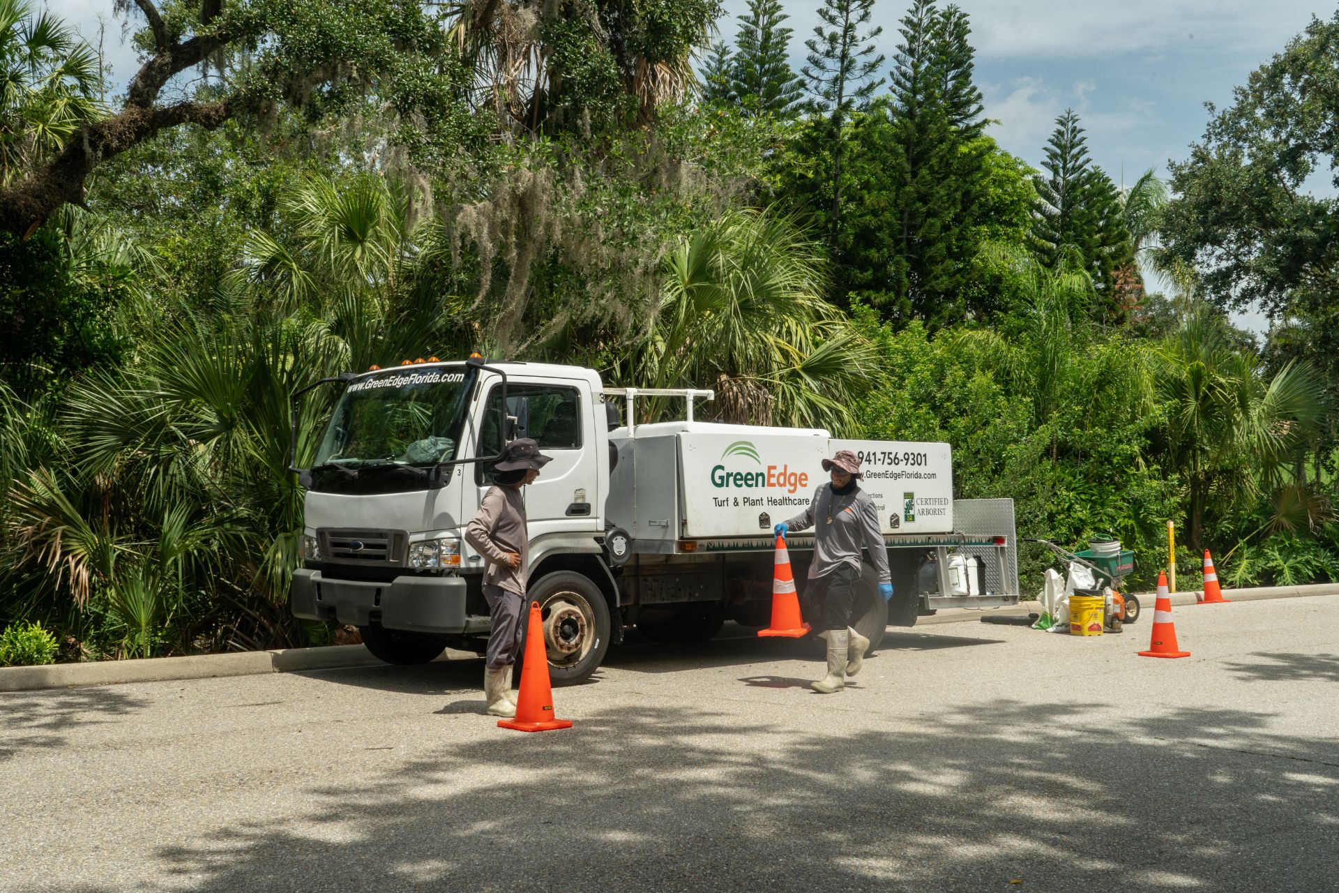 Two GreenEdge staff members diligently placing traffic cones on the road in Sarasota. Our dedicated team prioritizes safety and takes necessary precautions during landscaping and maintenance activities. Trust GreenEdge for a professional and responsible approach to ensure the well-being of both our staff and the public.